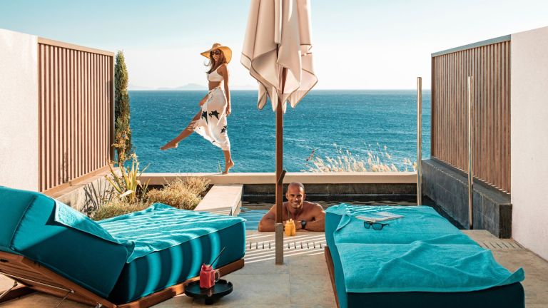 Vrouw genietend van het uitzicht op de rand van een luxe infinity pool bij een hotel met korte transfertijd.